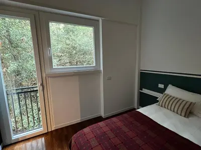 a bedroom with a bed and two windows at Orti18 - Ponte Milvio in Rome