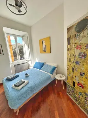 a bedroom with a bed with blue sheets and a window at Luxury Apartment - Centro Storico San Pietro in Rome