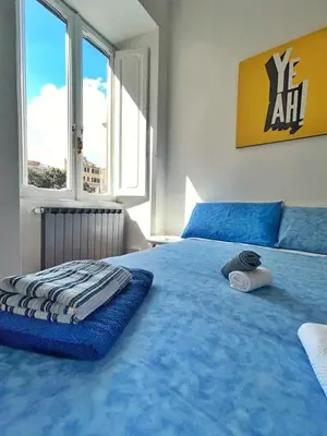 a large blue bed in a room with windows at Luxury Apartment - Centro Storico San Pietro in Rome
