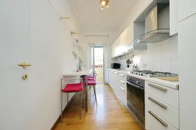 a kitchen with white cabinets and red stools at YCH-Confortevole appartamento vicino Ponte Milvio in Rome