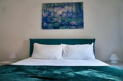 a bedroom with a bed with a painting on the wall at Emerald - in the heart of Trastevere in Rome