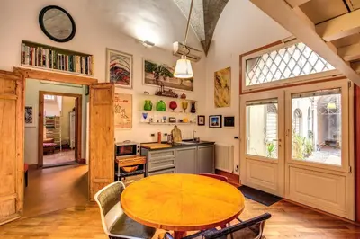a dining room with a table and a kitchen at YourSuiteRome in Rome