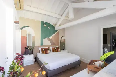 a bedroom with a white bed and a painting on the wall at iFlat The Great Beauty in Rome