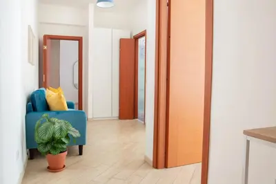 a hallway with a blue chair and a potted plant at Esclusivo Appartamento di design (metro Tiburtina) in Rome