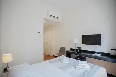 a bedroom with a bed and a desk with a tv at OperaDreams2 in Rome