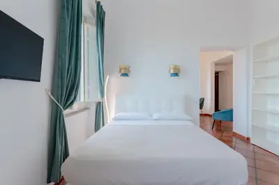 a bedroom with a white bed and a tv at The Attico: best view of Rome in Rome