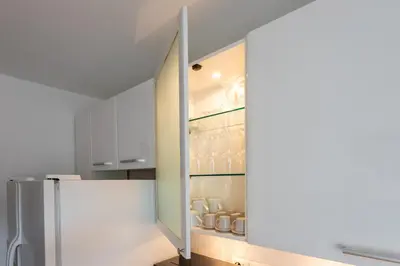 a kitchen with a refrigerator and white cabinets at The Attico: best view of Rome in Rome