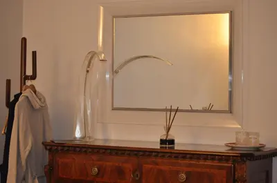 a bathroom with a large mirror and a wooden dresser at A casa di Pelé suite in Rome