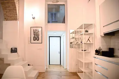 a hallway with white walls and stairs with a door at Via Veneto Luxury Loft in Rome