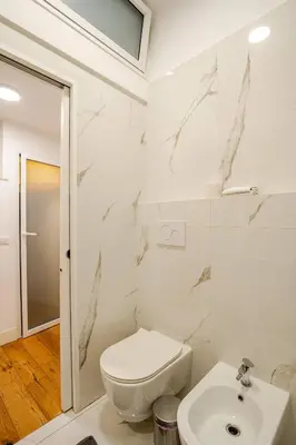 a white bathroom with a toilet and a sink at Via Veneto Luxury Loft in Rome