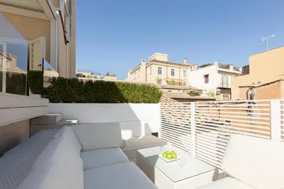 a small balcony with a white couch on a building at Amazing Piazza Venezia with Jacuzzi and terrace in Rome