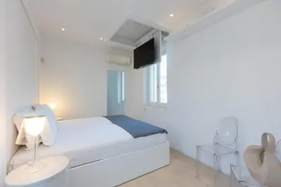 a white bedroom with a bed and a tv at Amazing Piazza Venezia with Jacuzzi and terrace in Rome