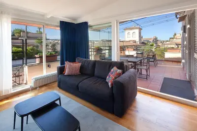 a living room with a couch and a large window at Migliori Collection Penthouse in Rome