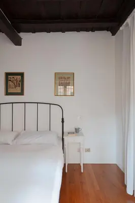 a white bedroom with a bed and a table at Elegante rifugio in centro storico Roma tra Piazza del Popolo e Piazza di Spagna in Rome