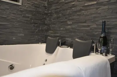 a bath tub with two chairs and a bottle of wine at Il Corso Suite in Rome