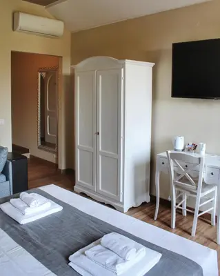 a bedroom with a bed and a desk and a television at Relais La Fornarina 2 in Rome