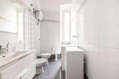 a white kitchen with a sink and a stove at Casa amoR in Trastevere in Rome