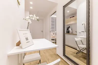 a mirror in a white room with a table and chairs at Principe Umberto Suite - Stazione Termini in Rome