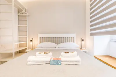 a white bedroom with a bed with towels on it at Principe Umberto Suite - Stazione Termini in Rome