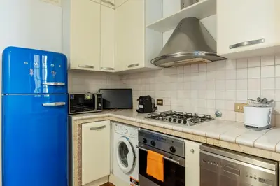 a kitchen with a blue refrigerator and a dishwasher at A stone’s throw from the Colosseum! in Rome