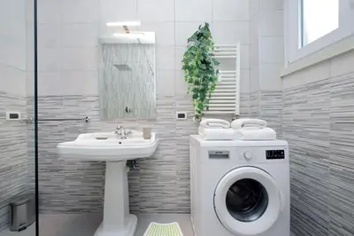 a bathroom with a washing machine and a sink at Comfy apartment next to Vatican City in Rome