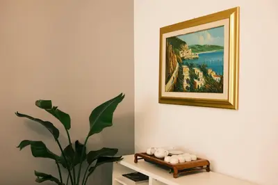 a painting on a wall next to a table with a plant at Termini Rita House in Rome
