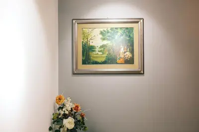 a painting hanging on a wall with a vase of flowers at Termini Rita House in Rome