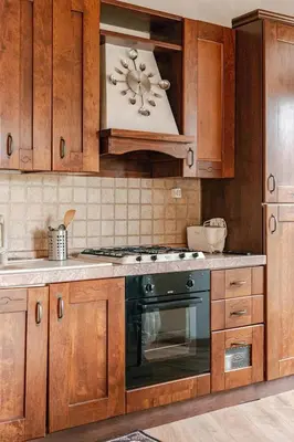 a kitchen with wooden cabinets and a stove top oven at Dimora di Trastevere in Rome
