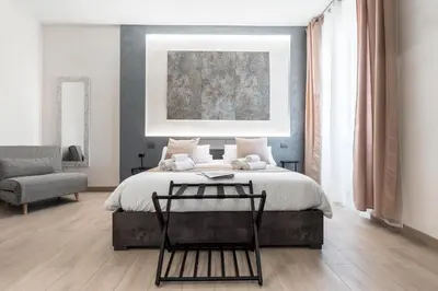 a bedroom with a large bed and a chair at Domus Æterna - Re di Roma in Rome