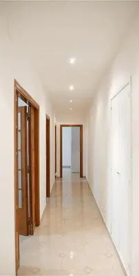 an empty hallway with white walls and tile floors at AURA APARTMENT in Rome