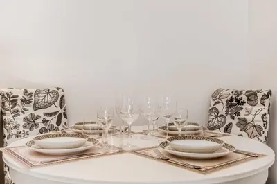 a white table with glasses and plates and chairs at La Rosa Dei Papi in Rome