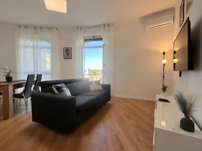 a living room with a black couch and a table at PyramidHouse Rome - Apartment 100mq with View - 2km from the Colosseum in Rome