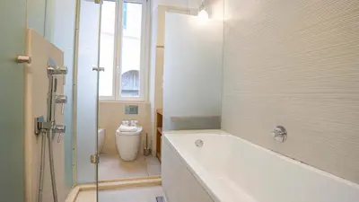 a bathroom with a bath tub and a toilet at EasyTopStay - Trastevere Cozy Nest with Terrace in Rome
