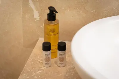 three bottles of moisturizers sitting next to a toilet at Amazing Cozy Piazza Venezia in Rome