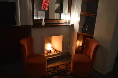 a fireplace with a fire in it with two chairs at Colosseum Colosseo in Rome