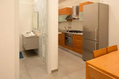 a kitchen with a stainless steel refrigerator and wooden cabinets at Élite Vatican Refuge in Rome