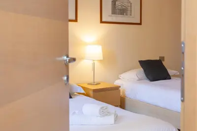 a small room with two beds and a lamp at Trastevere Garden by Rental in Rome in Rome