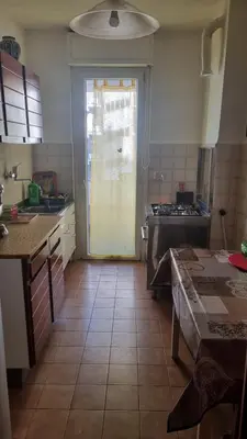 a kitchen with a door leading into a kitchen with a table at Dreamy Family Getaway Guest House Roma 2BR,2BA in Rome
