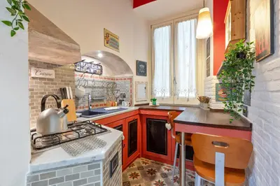 a kitchen with red cabinets and a stove top oven at Rome as you feel - Casa Governo Vecchio in Rome