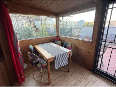 a small room with a table and chairs and windows at Chalet dei Girasoli in Rome