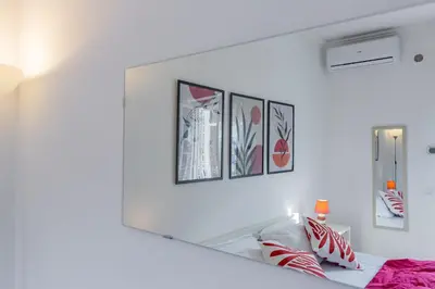 a mirror on a white wall with framed pictures at Milvio Bridge - Olympic Stadium, Farnesina, A-C in Rome