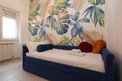 a bedroom with a blue bed with a floral wallpaper at Piramide - Charme Apartment in Rome
