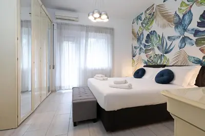 a bedroom with a large bed with blue pillows at Piramide - Charme Apartment in Rome