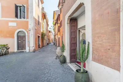 an empty alley with cactuses in front of a door at L'antico borgo di Trastevere III in Rome