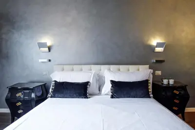 a bedroom with a large white bed with blue pillows at Navona Secret Stay Guest House in Rome