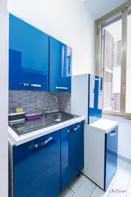 a blue kitchen with a sink and blue cabinets at Cairoli 2 House G&B Termini in Rome