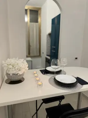 a table with two glasses and a vase of flowers at Cairoli 2 House G&B Termini in Rome