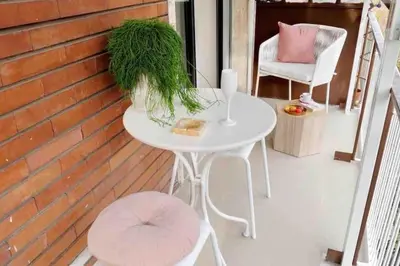 a white table and chairs on a porch with a table and grass at YCH TRILOCALE FINEMENTE ARREDATO VICINO ALLA METRO in Rome