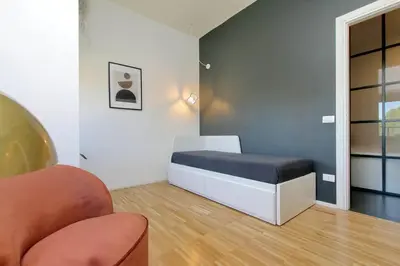 a small room with a bed and a chair at YCH TRILOCALE FINEMENTE ARREDATO VICINO ALLA METRO in Rome