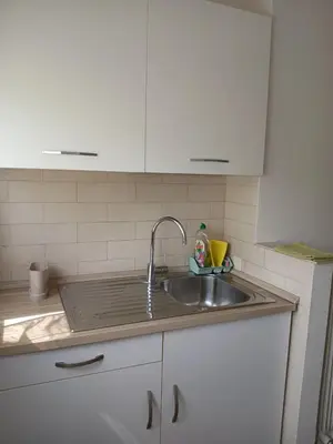 a kitchen counter with a sink and white cabinets at La Piccoletta di Garbatella in Rome